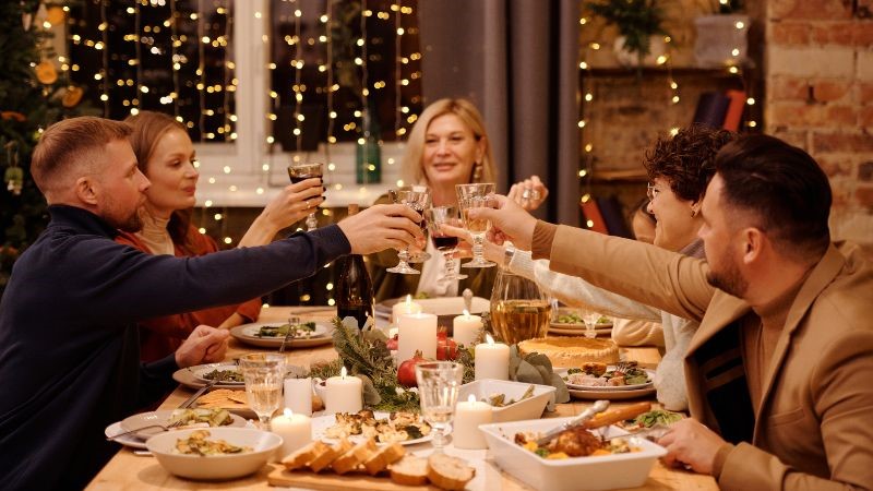 a family cheers over their Christmas dinner to celebrate the special occasion and reconnecting