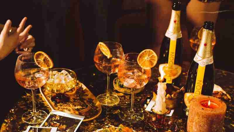 Chandon Spritz is serves on a table full of gold confetti and people making merry times
