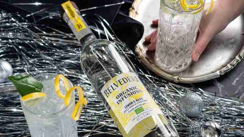 Belvedere Organic Infusions Lemon and Basil sits atop some sparkling tinsel and the serves surround it in another making merry party