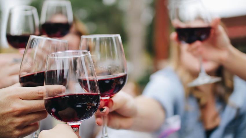 People Sat Around Together Drinking English Wine